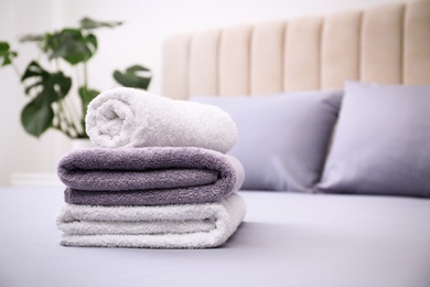 Soft clean towels on bed indoors. Space for text