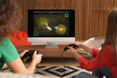 Photo of Young women playing video games at home
