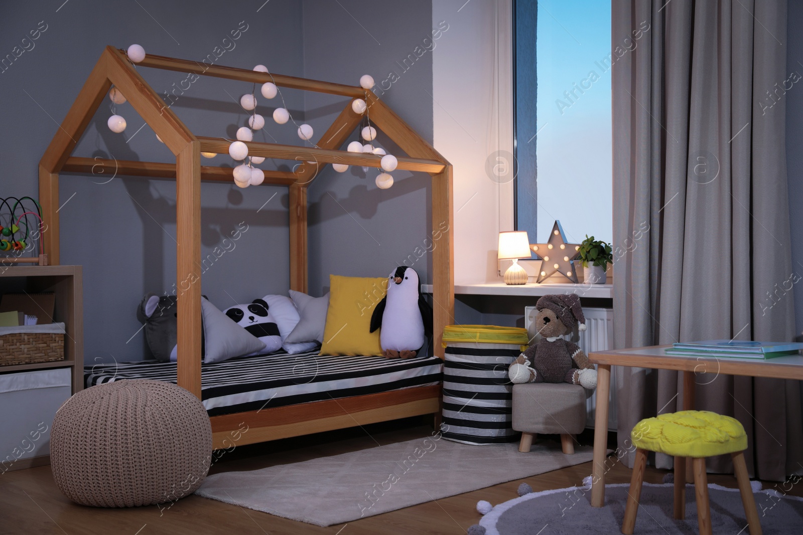 Photo of Stylish child room interior with comfortable house bed and toys