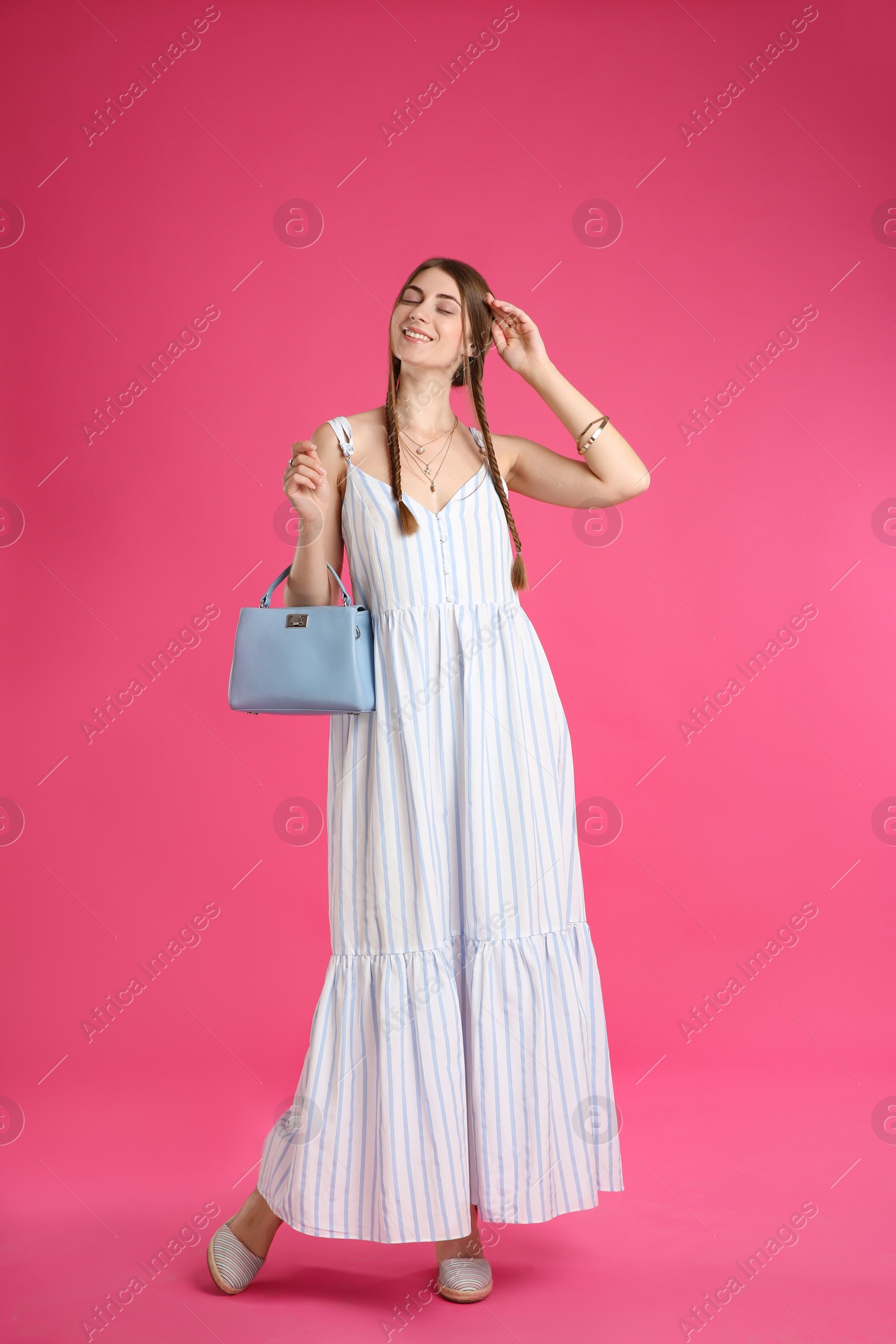 Photo of Beautiful young woman with stylish blue bag on pink background