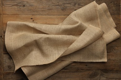 Burlap fabric on wooden table, top view