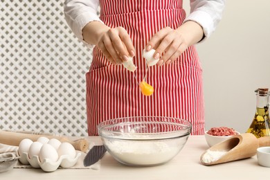 Photo of Woman making dough at white wooden table, closeup