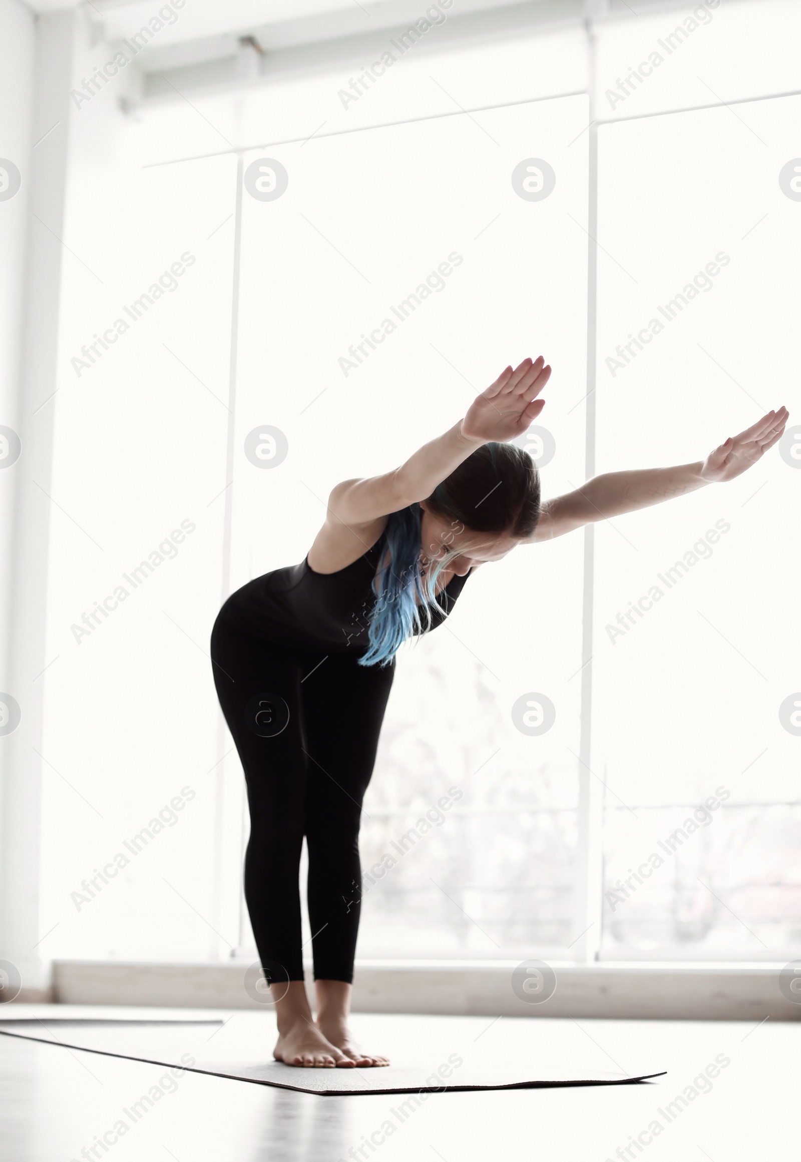 Photo of Young woman practicing yoga indoors