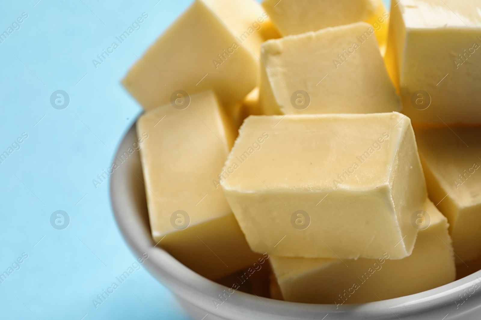 Photo of Bowl with fresh butter on color background, closeup