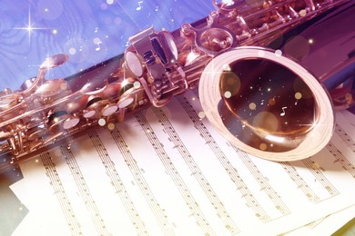 Image of Beautiful saxophone and note sheets on table, closeup