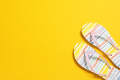 Photo of Bright flip flops on color background, top view with space for text. Beach accessories