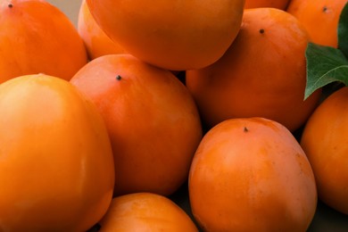 Photo of Pile of delicious ripe juicy persimmons as background, closeup