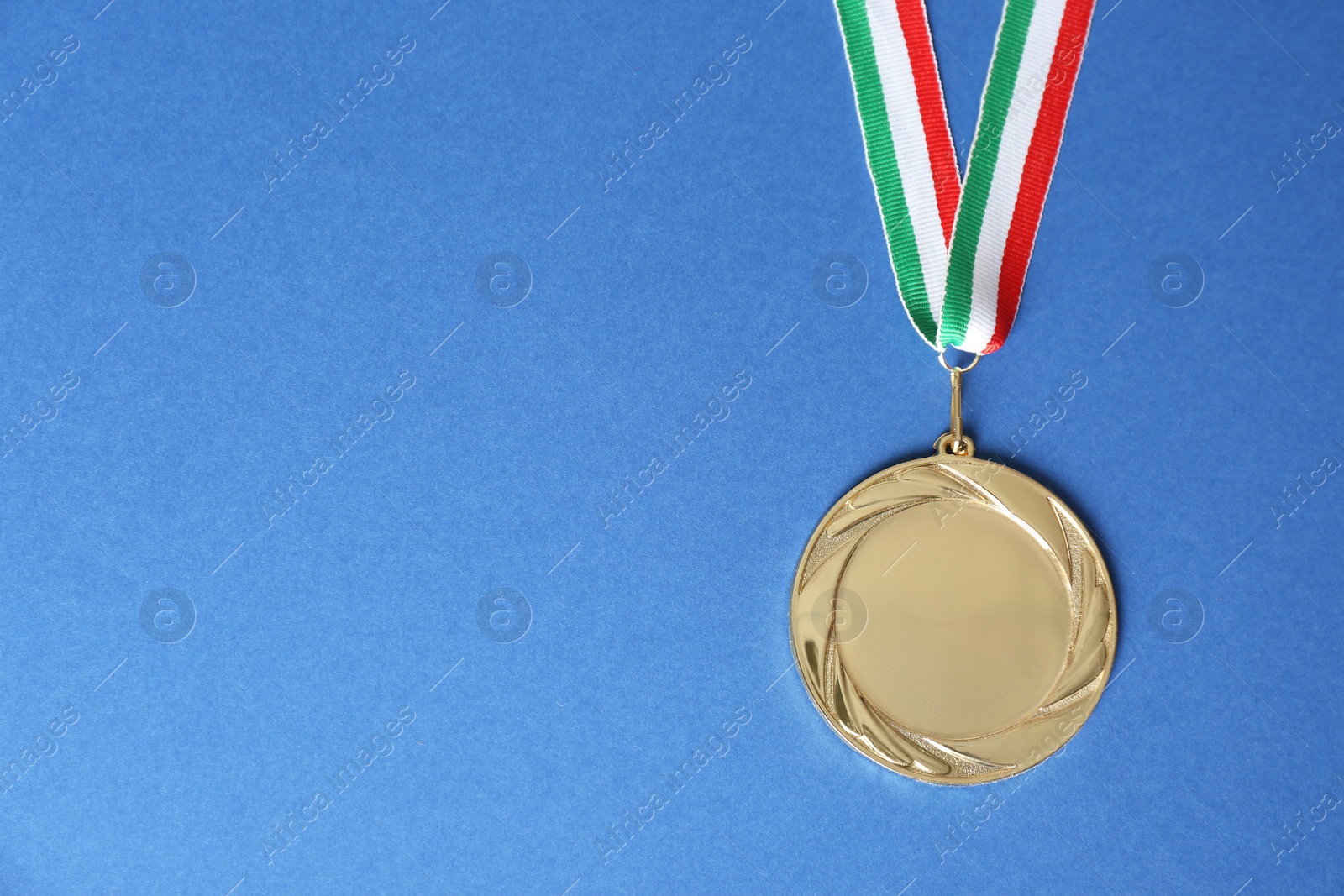Photo of Gold medal on blue background, top view. Space for design