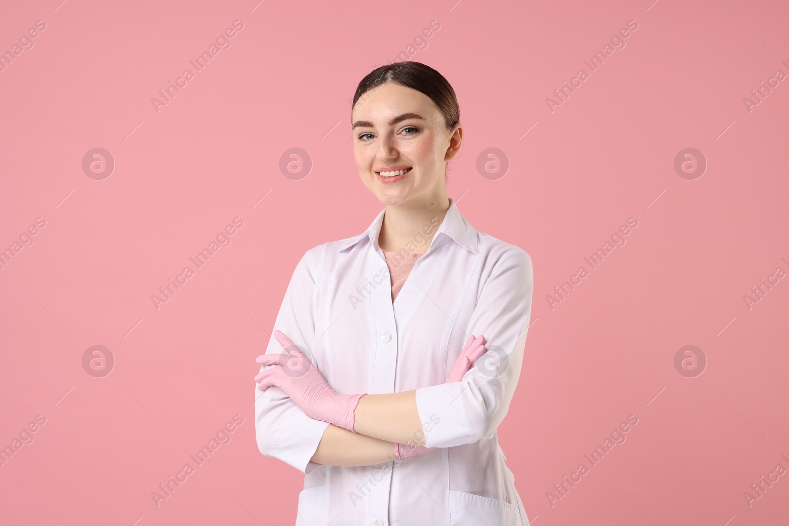 Photo of Cosmetologist in medical uniform on pink background