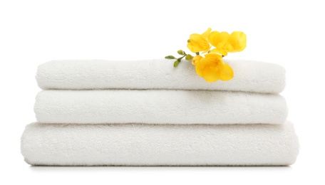 Photo of Stack of clean folded towels with flowers on white background