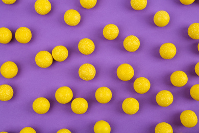 Delicious lemon chewing gums on purple background, flat lay