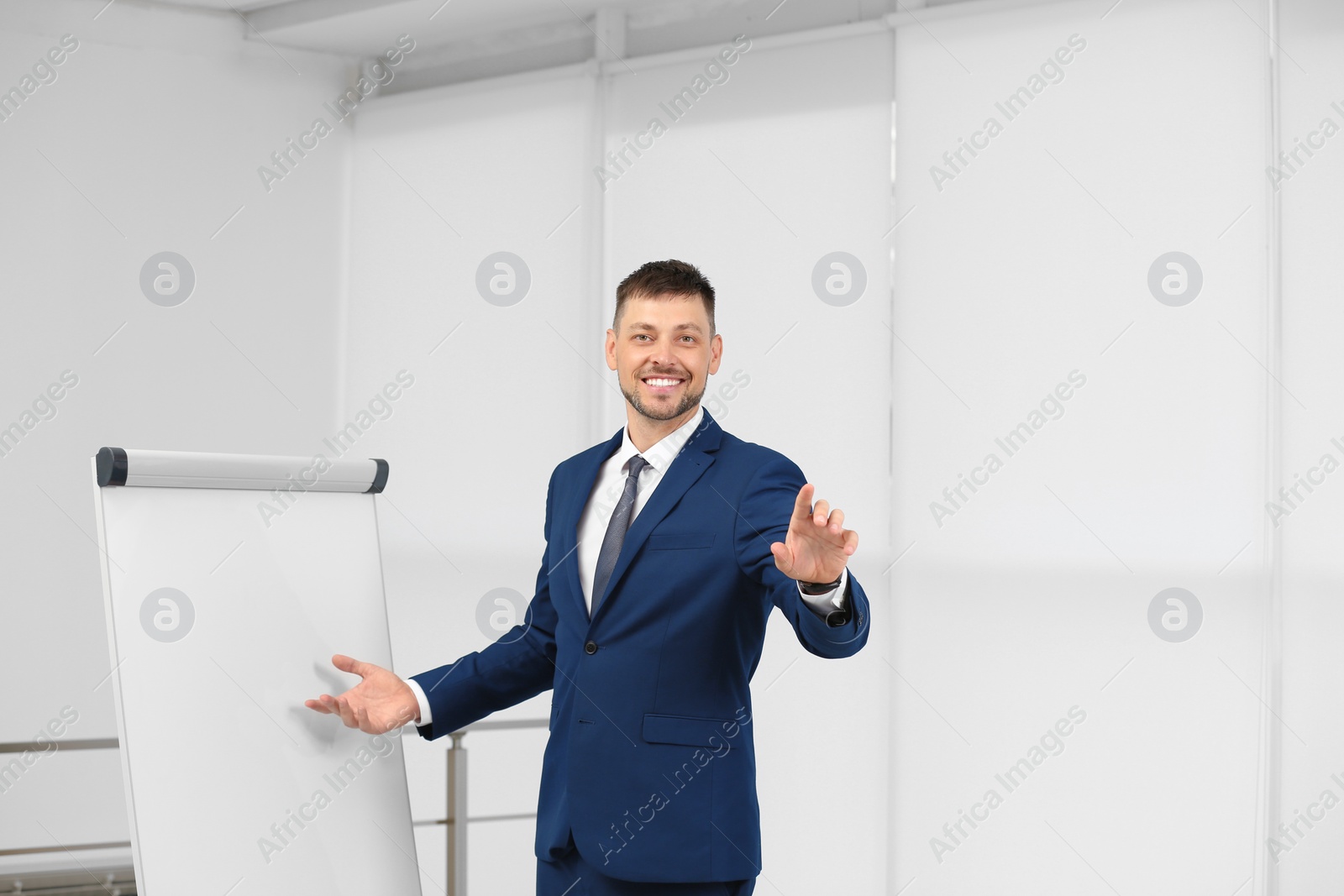 Photo of Professional business trainer near flip chart board indoors. Space for text