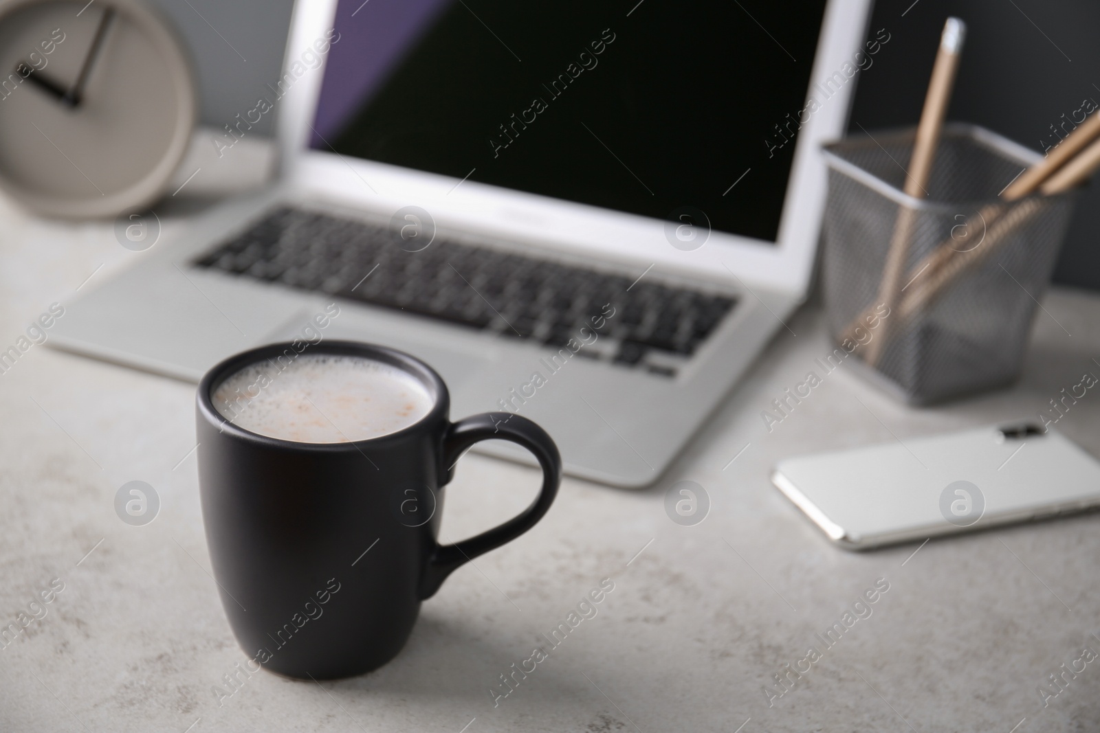 Photo of Black cup with coffee on office table. Space for text