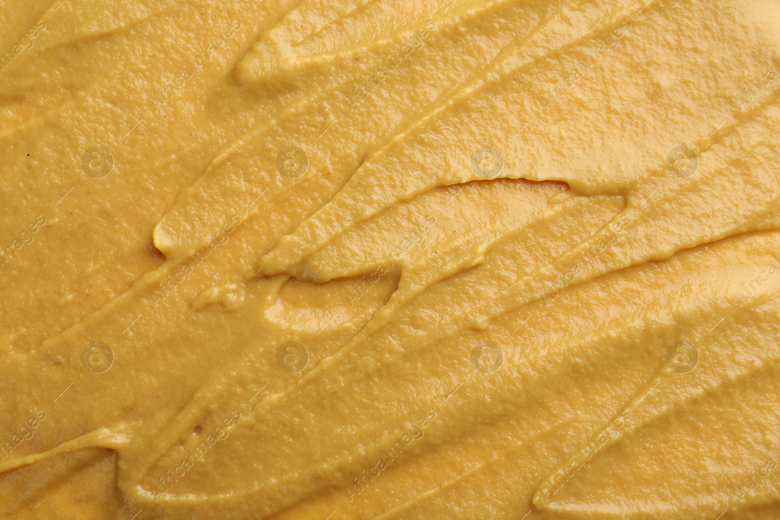 Photo of Fresh tasty mustard sauce as background, top view