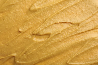 Photo of Fresh tasty mustard sauce as background, top view