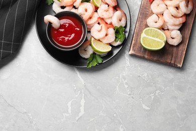 Photo of Tasty boiled shrimps with cocktail sauce, parsley and lime on light grey table, flat lay. Space for text