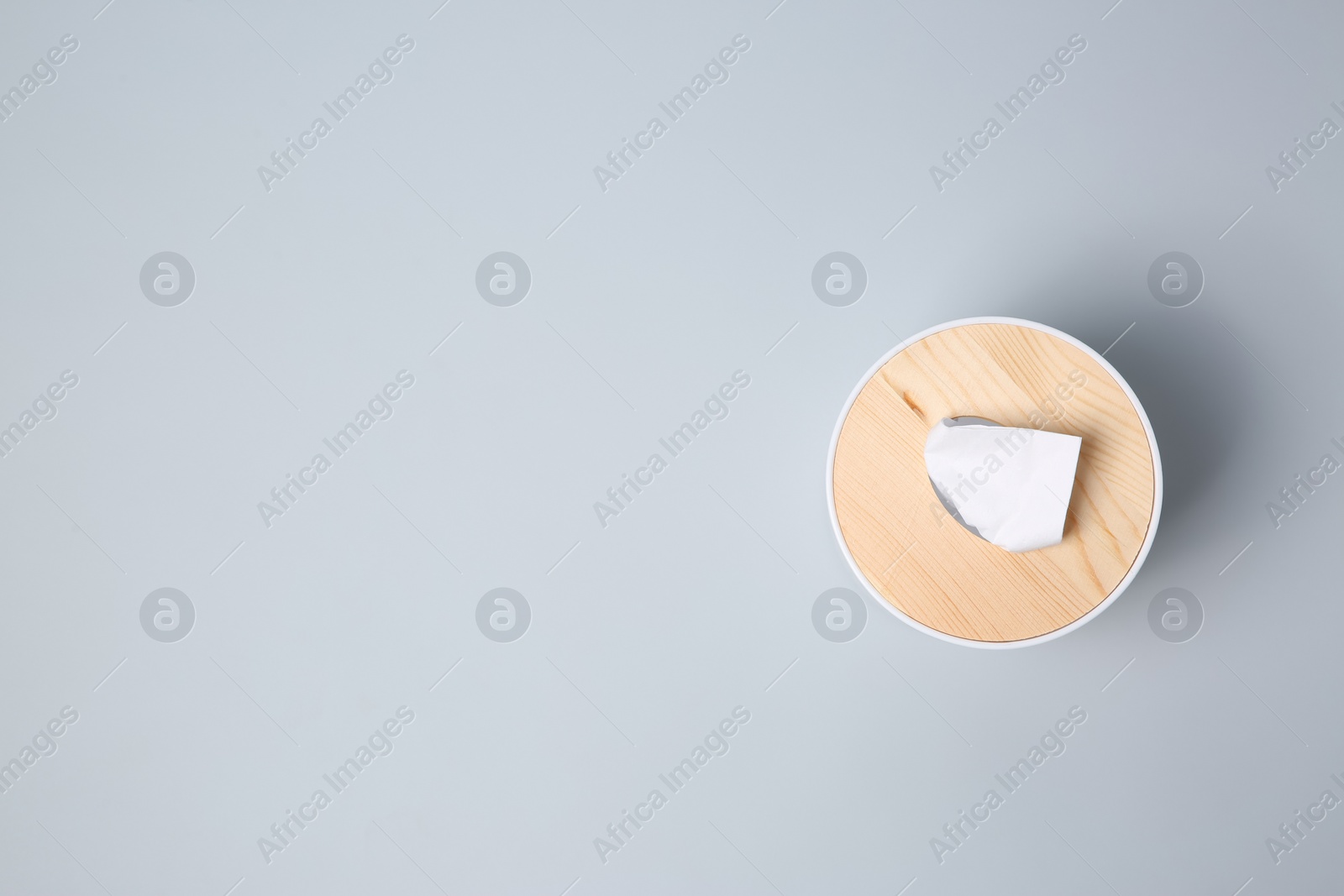 Photo of Holder with paper tissues on light grey background, top view. Space for text