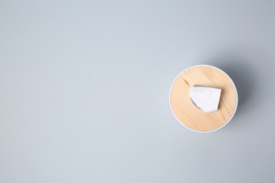 Holder with paper tissues on light grey background, top view. Space for text