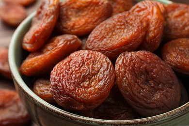 Photo of Closeup view of tasty apricots in bowl. Dried fruits