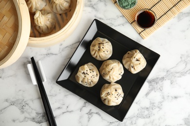 Photo of Plate with tasty baozi dumplings served on marble table, top view