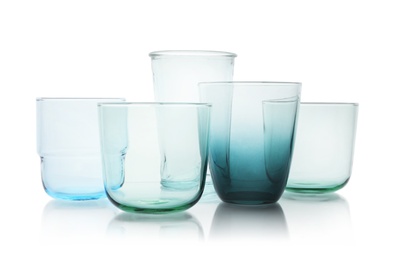 Photo of Set of colorful empty glasses on white background