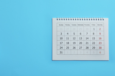 Paper calendar on light blue background, top view. Space for text