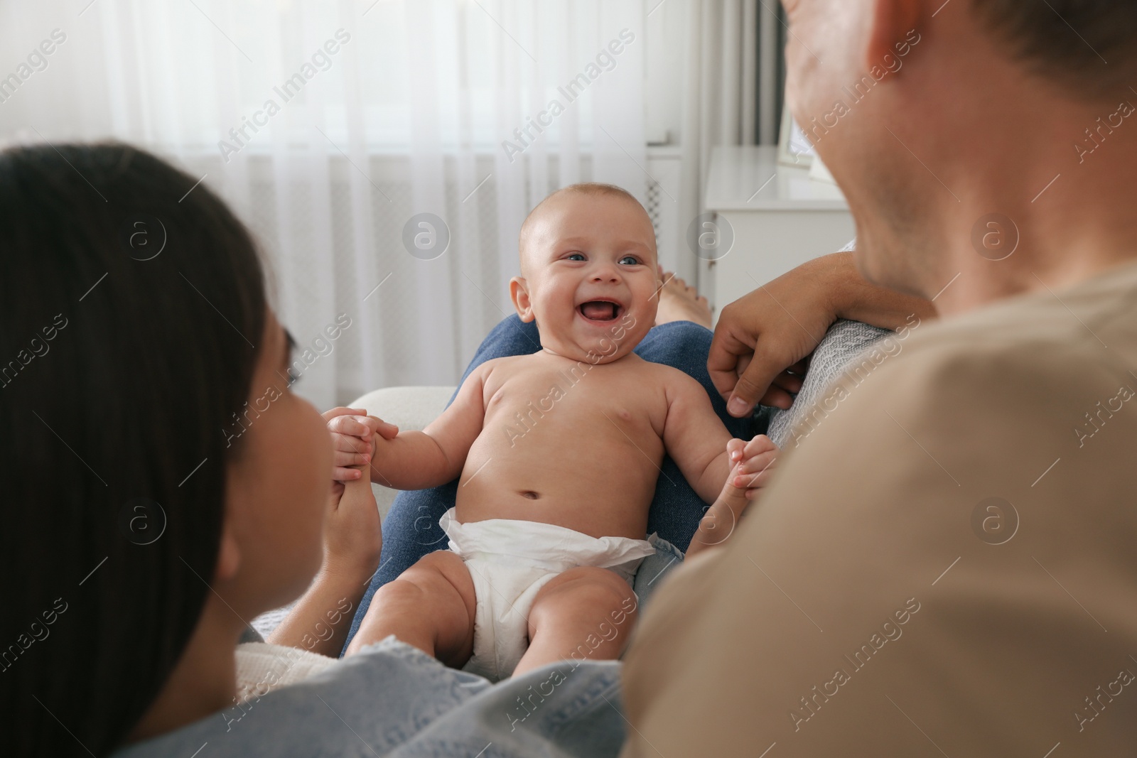 Photo of Happy family with their cute baby at home