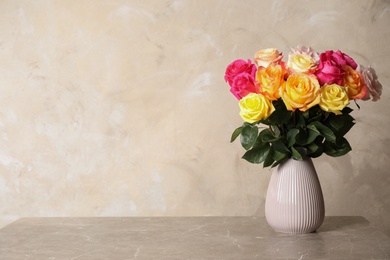 Photo of Luxury bouquet of fresh roses on grey table. Space for text