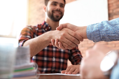 Photo of Business partners shaking hands after meeting, closeup