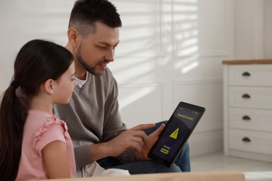 Dad installing parental control on tablet at home. Child safety