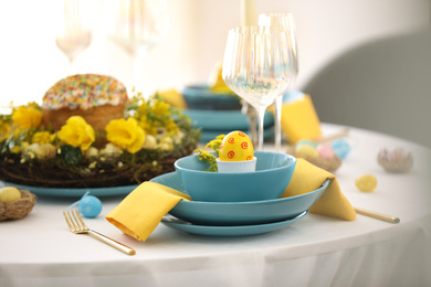 Festive Easter table setting with beautiful floral decor and eggs indoors