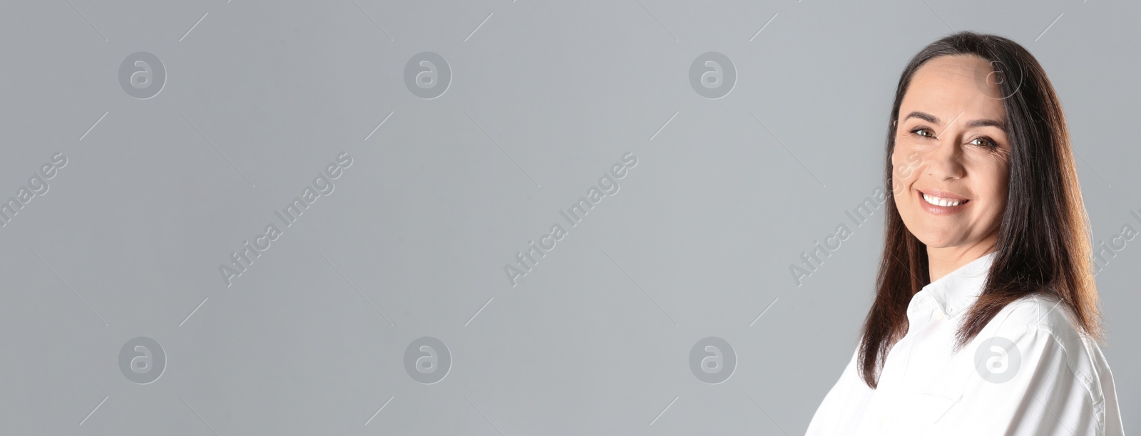 Image of Portrait of beautiful mature woman on grey background, space for text. Banner design
