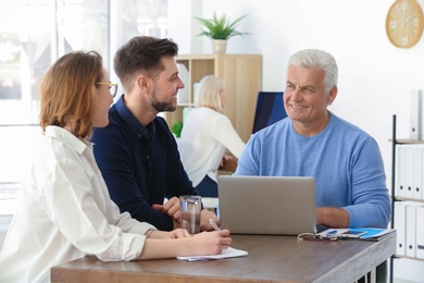 Photo of Mature manager consulting couple in office