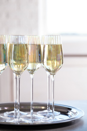 Photo of Glasses of champagne served on grey table