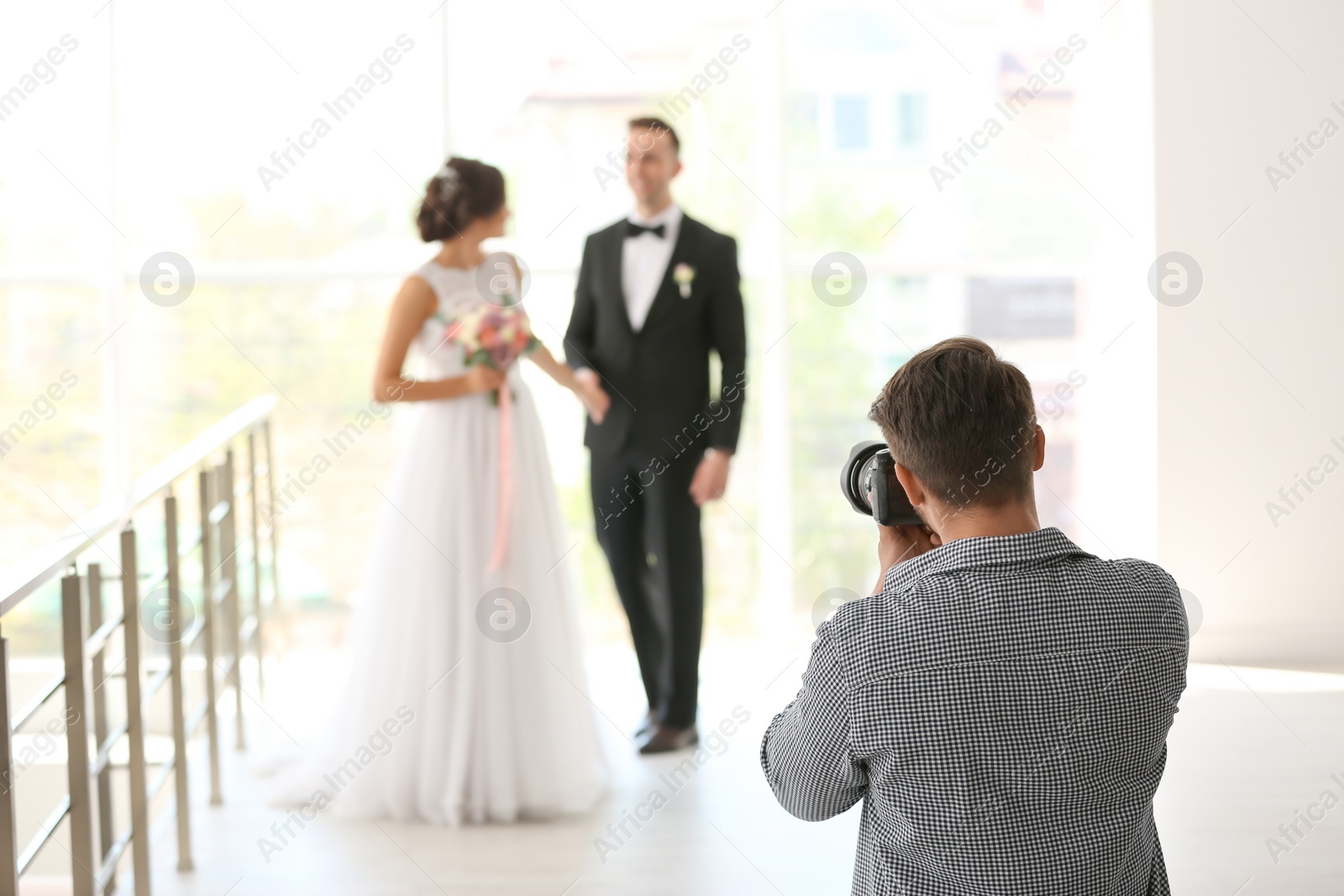 Photo of Professional photographer taking photo of wedding couple in studio