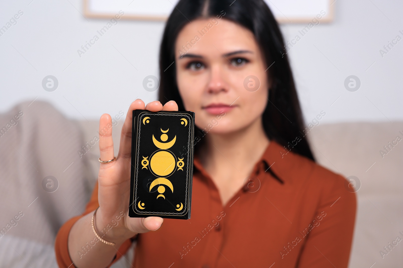 Photo of Soothsayer predicting future indoors. Focus on tarot cards