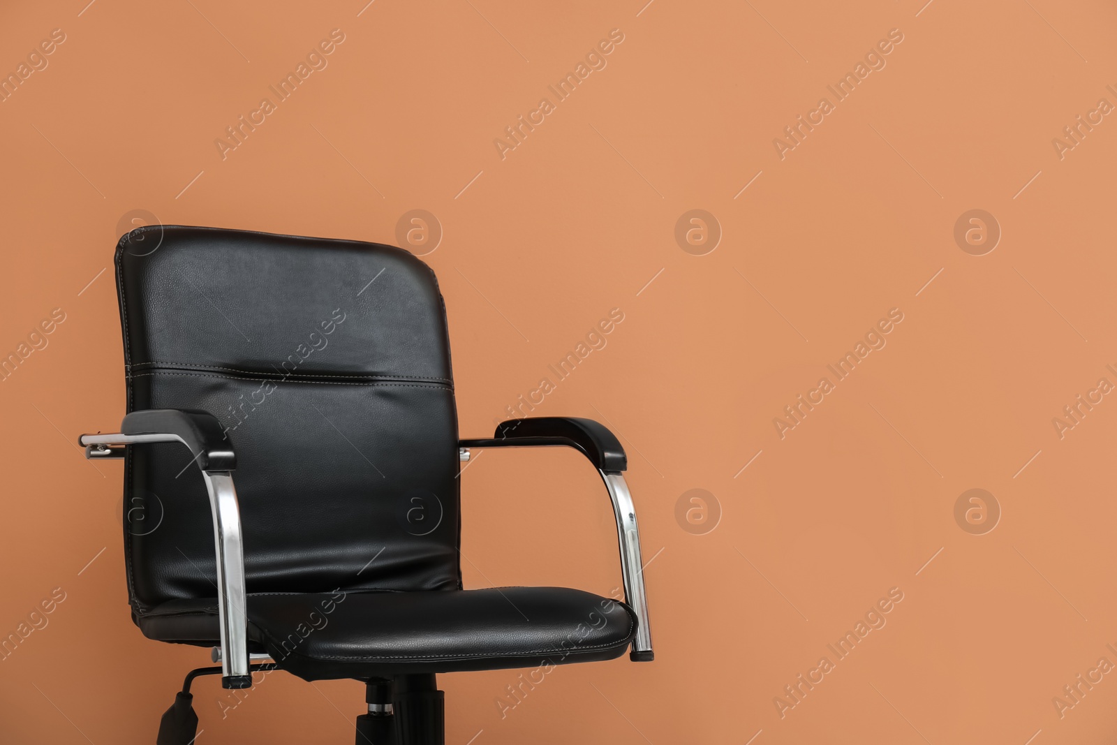 Photo of Modern office chair on orange coral background. Space for text