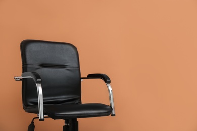 Photo of Modern office chair on orange coral background. Space for text