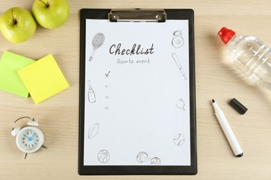 Photo of Sports Event Checklist. Flat lay composition with clipboard, alarm clock and bottle of water on wooden background