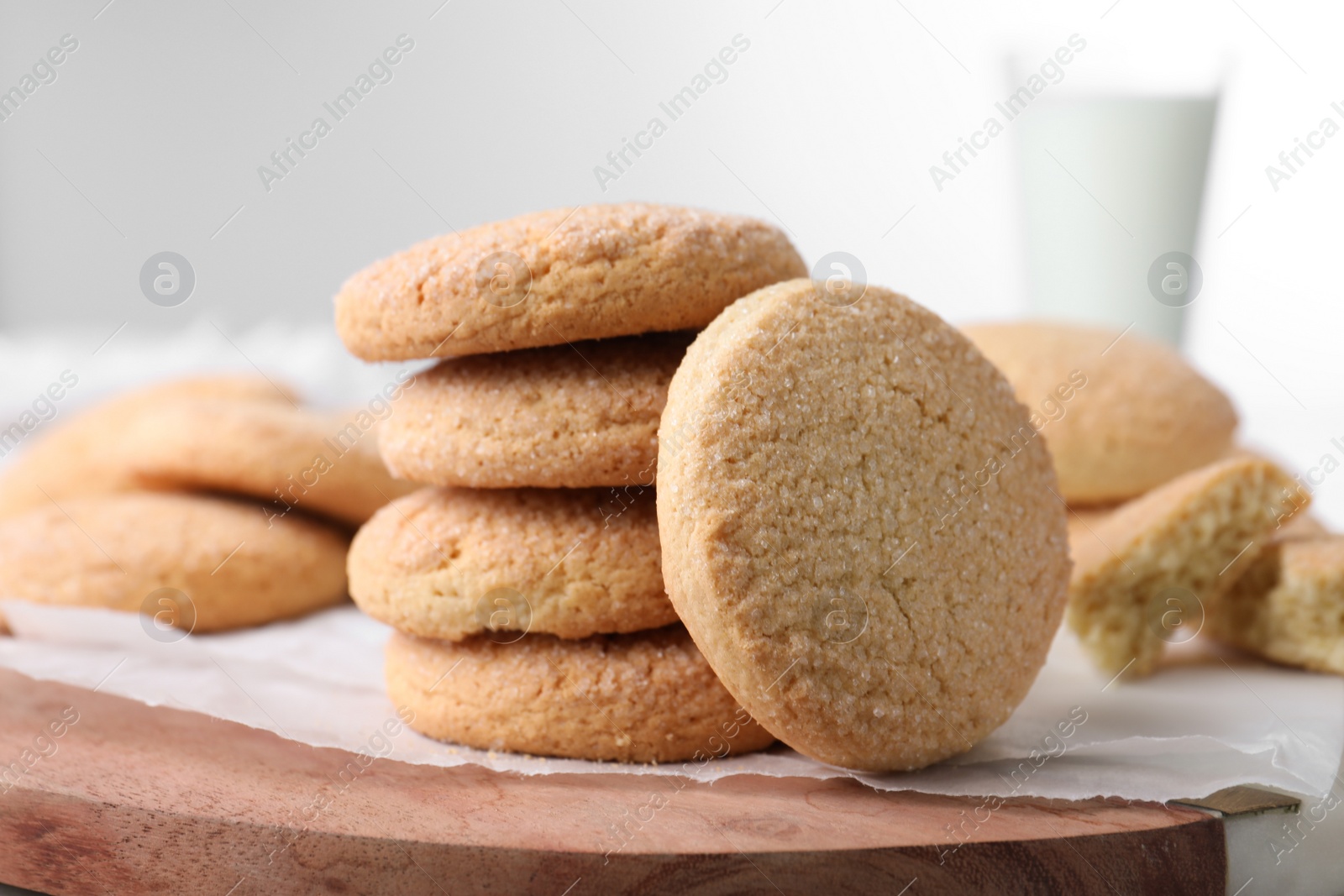 Photo of Many tasty sugar cookies on wooden board, closeup