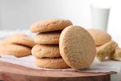 Many tasty sugar cookies on wooden board, closeup