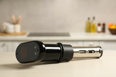 Photo of Thermal immersion circulator on white table in kitchen. Sous vide cooking