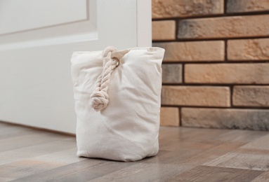 Photo of Stuffed bag holding wooden door at home