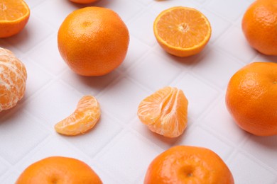 Photo of Fresh juicy tangerines on white tiled table