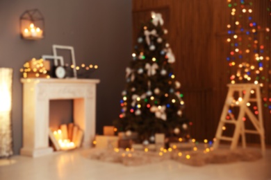 Photo of Blurred stylish room interior with Christmas tree and decorative fireplace