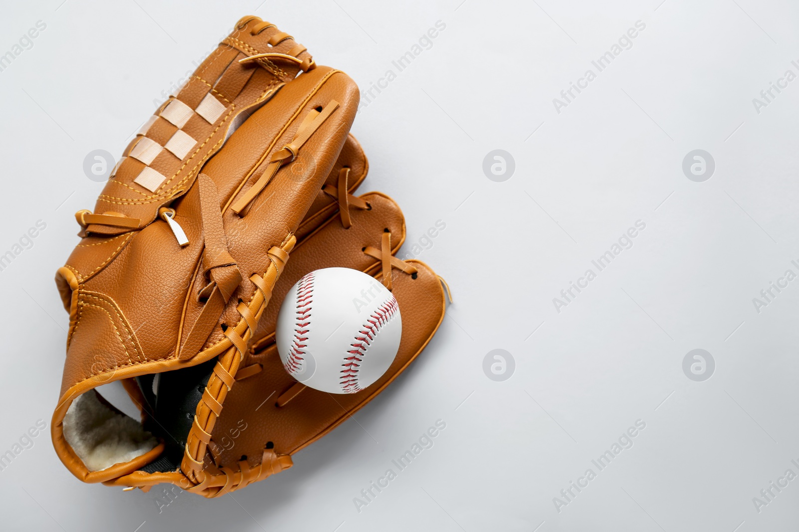 Photo of Catcher's mitt and baseball ball on white background, top view with space for text. Sports game