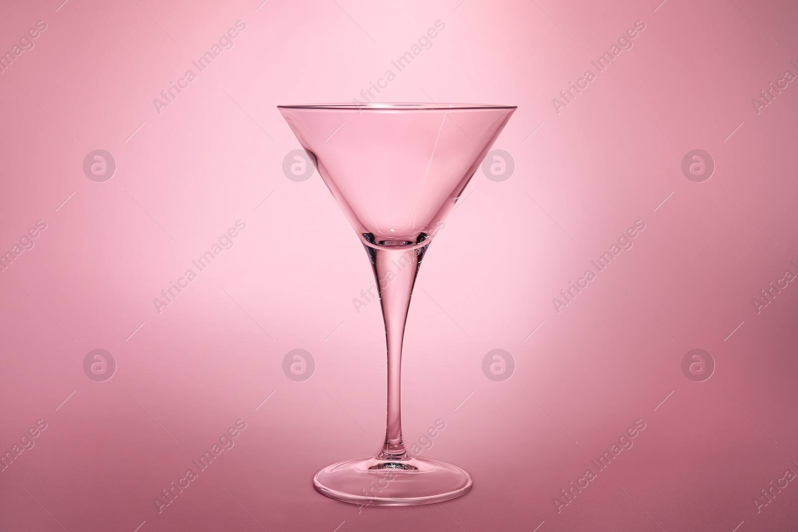 Photo of Elegant empty martini glass on pink background