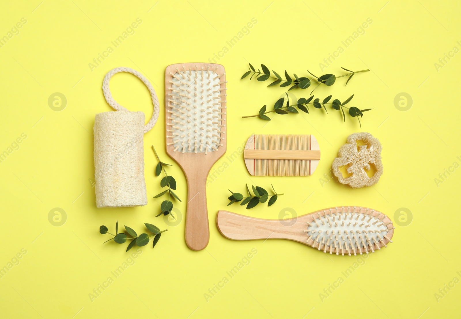 Photo of Flat lay composition with modern hair comb and brushes on yellow background