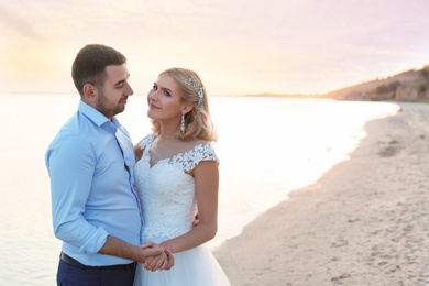 Photo of Wedding couple hugging on beach. Space for text