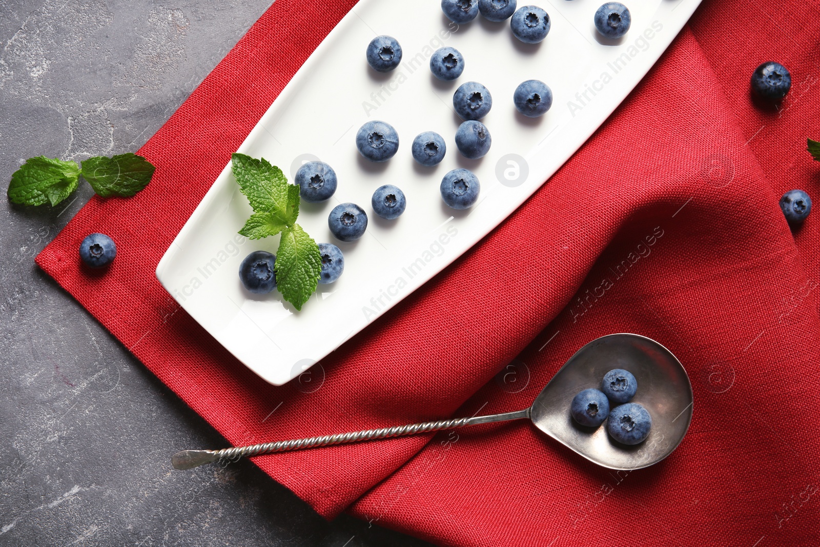 Photo of Flat lay composition with fresh blueberries on color table